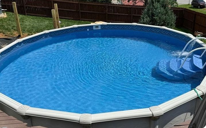 A large above-ground swimming pool filled with blue water and stairs.