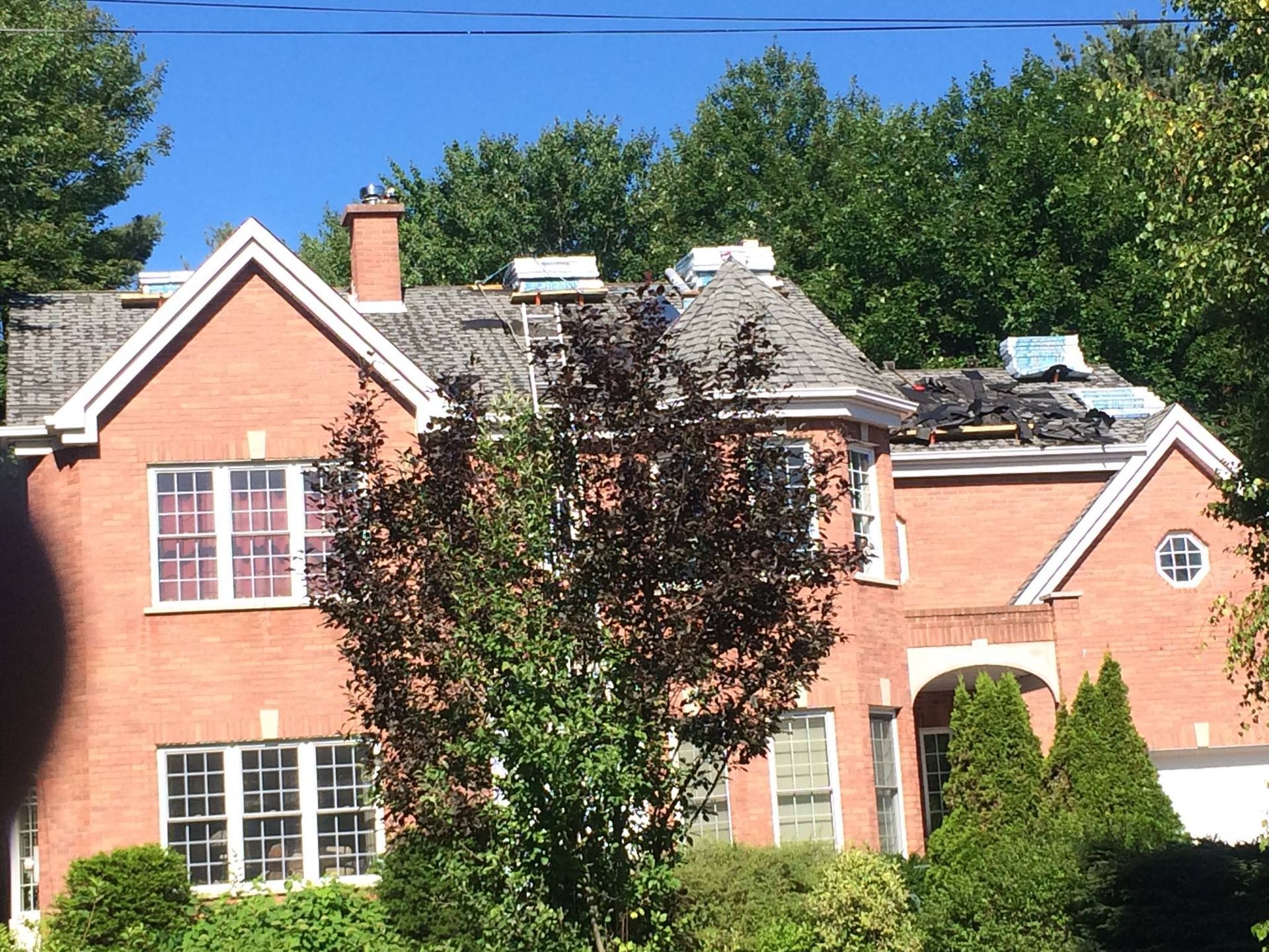 Une grande maison en brique avec un toit en réparation
