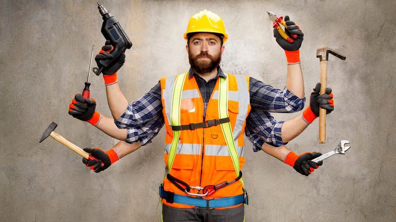 Homeowner using basic tools for DIY repairs before calling handyman services in Kingston