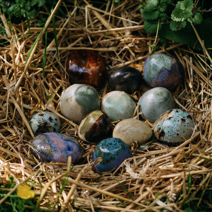nest van stro met koesterstenen van kleurig vorstbestendig keramiek. te gebruiken als kleine urn