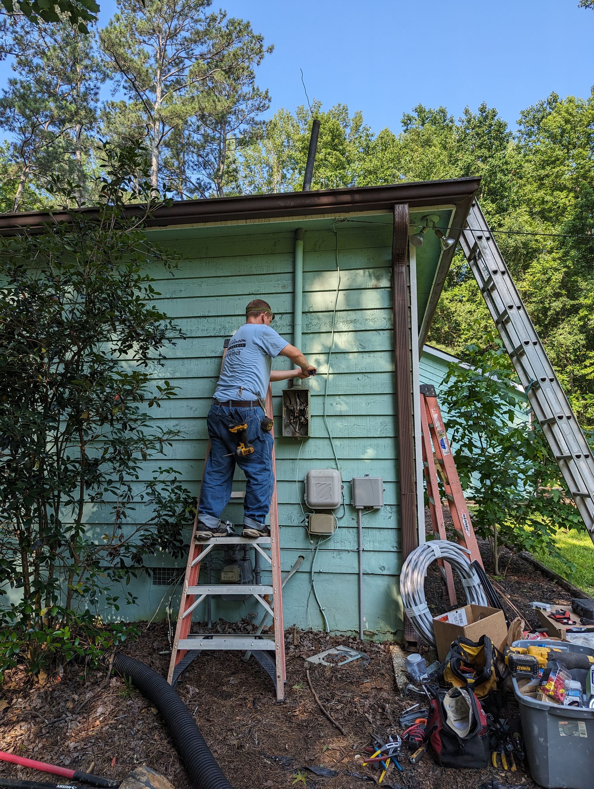 Low-profile LED puck lights installed under white kitchen cabinets, illuminating a white marble backsplash and wall outlet.