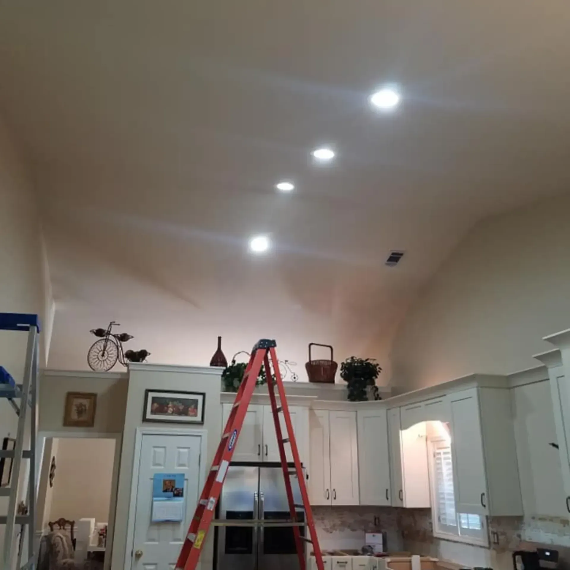Kitchen with recessed lights in ceiling; ladder in foreground