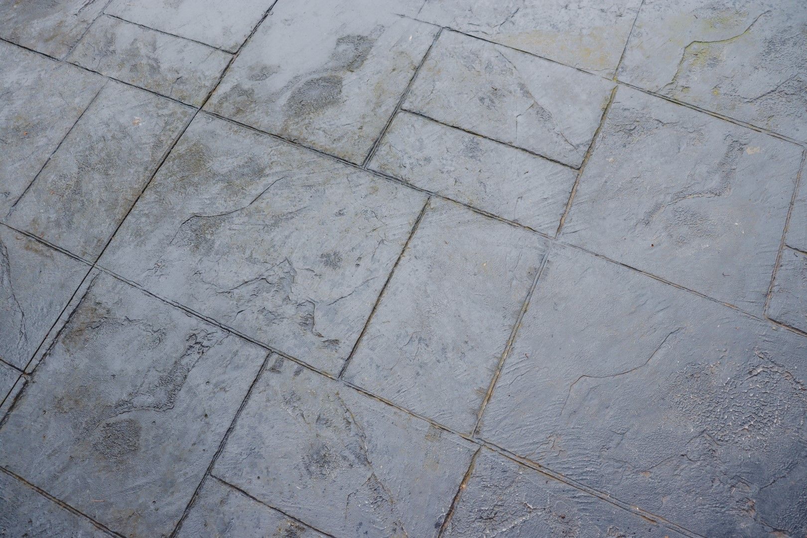 Gray stamped concrete patio with rectangular and square patterns.