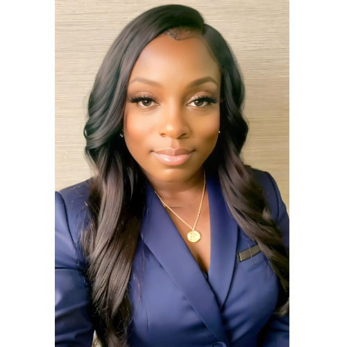 A woman wearing a blue jacket and a gold necklace is taking a selfie.