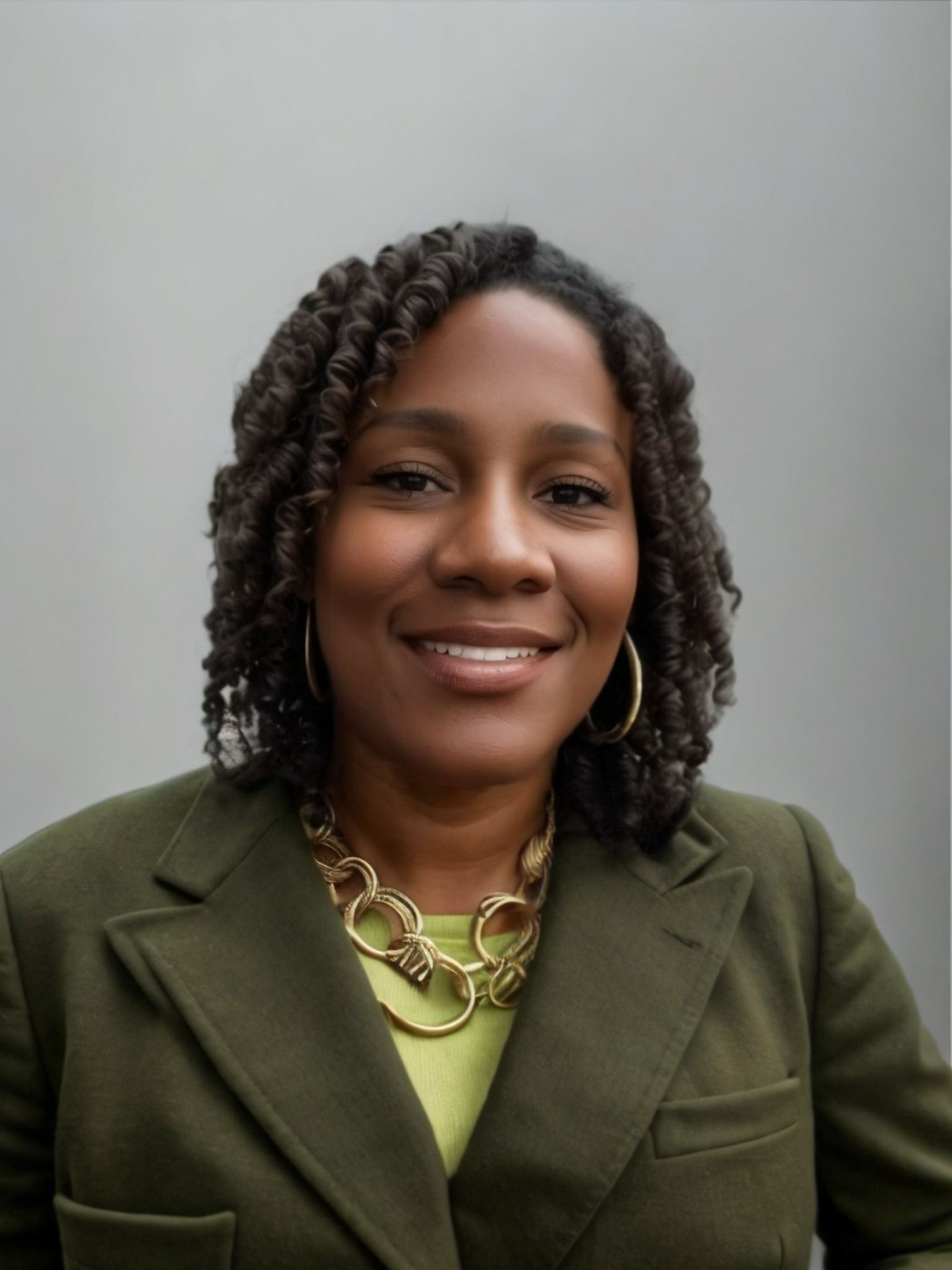 A woman wearing a green jacket and a gold necklace