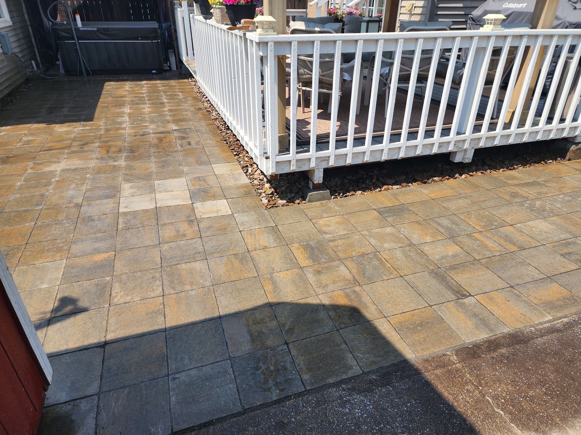 A patio with a white railing and a wooden deck.