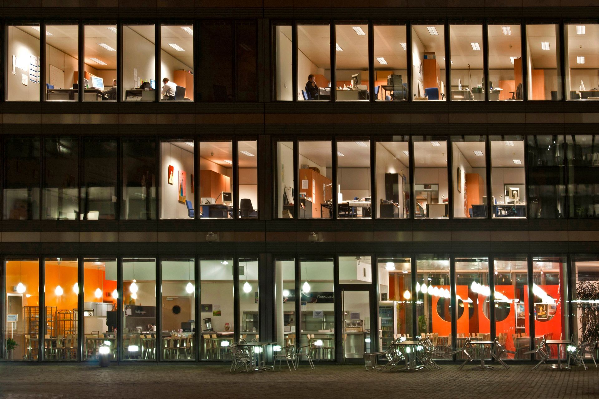 A large building with lots of windows is lit up at night
