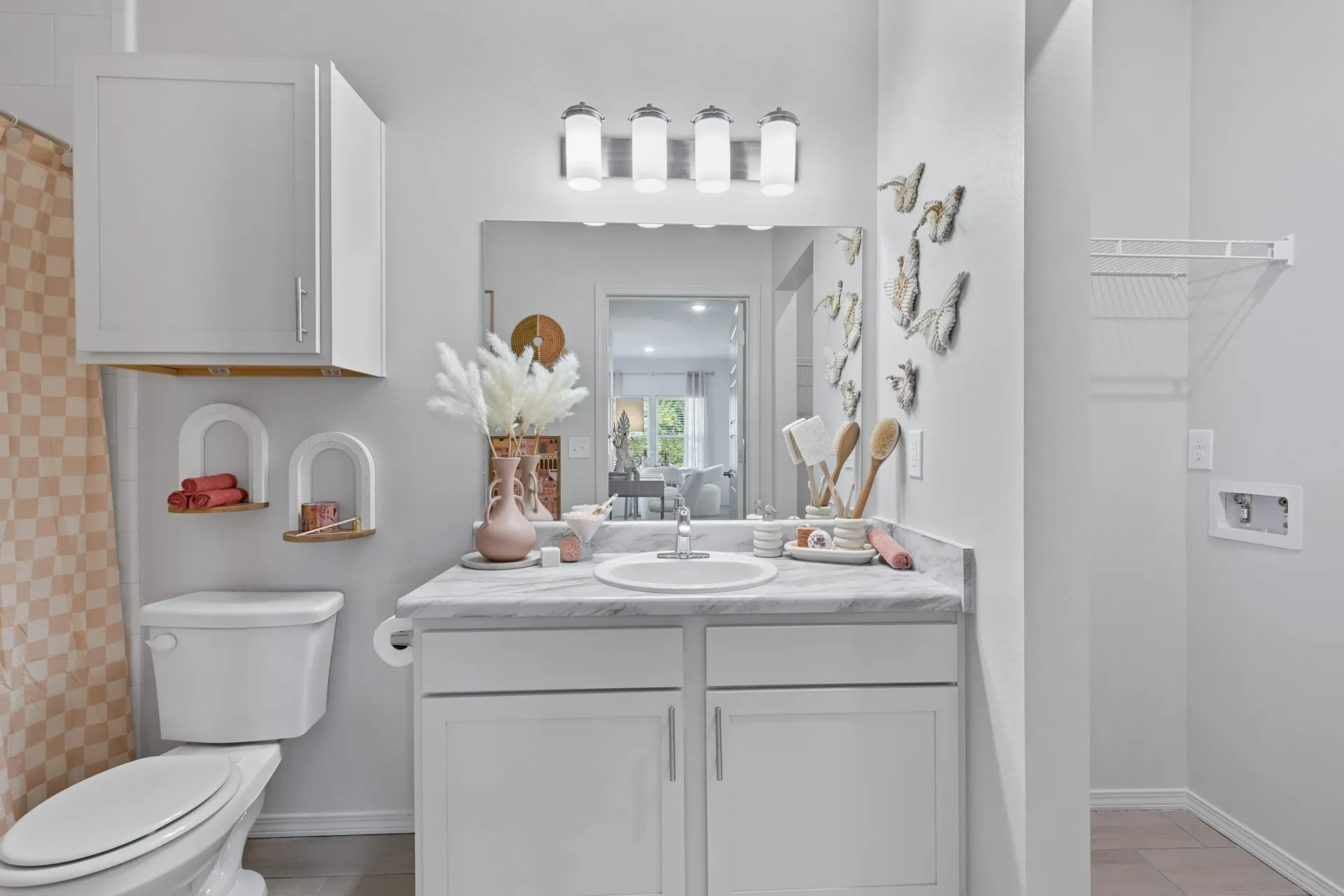 Modern bathroom with white cabinetry and decorative elements.