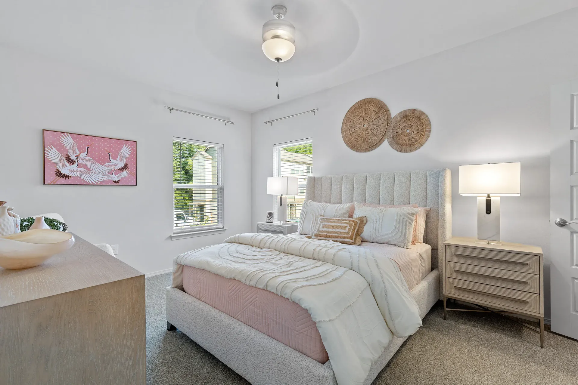 Brightly decorated bedroom with bed, nightstand, and wall artwork.