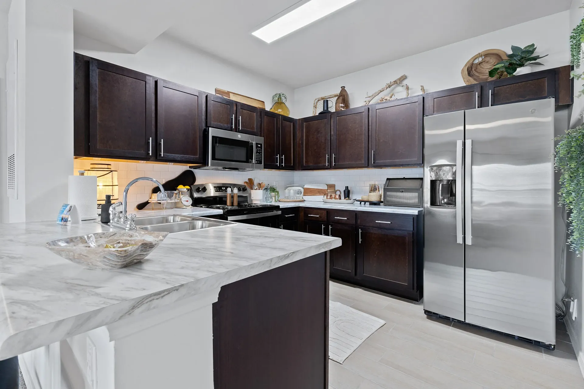 Modern kitchen featuring dark cabinetry and stainless steel appliances