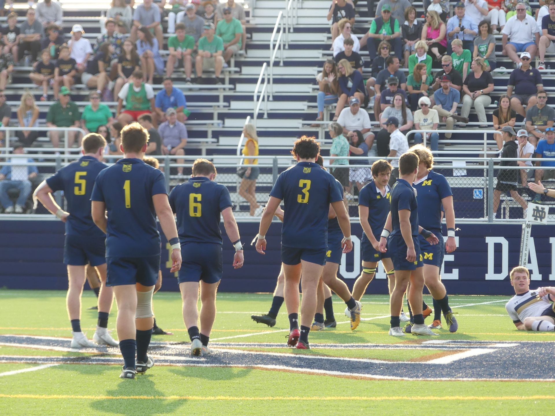 A group of rugby players are walking on the field