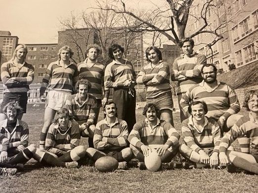 A black and white photo of a rugby team posing for a picture.