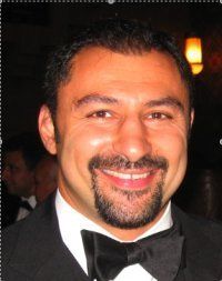 A man with a beard is wearing a tuxedo and bow tie