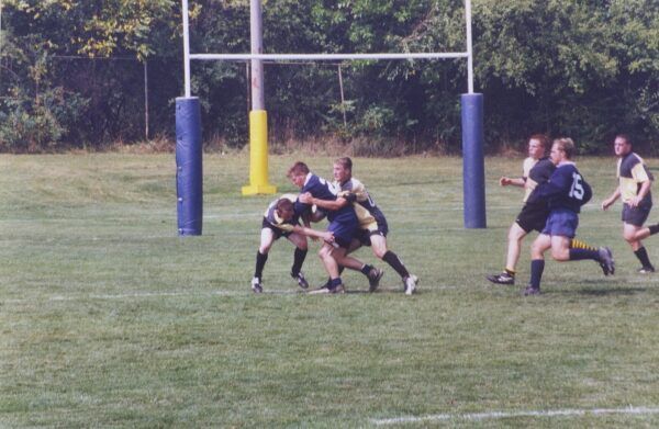 A group of men are playing a game of rugby on a field