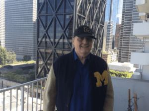 A man wearing a jacket with the letter m on it