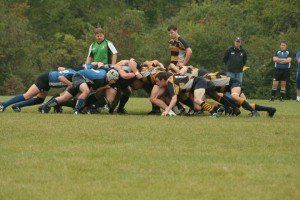 A group of rugby players are playing a game on a field.