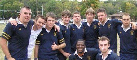 A group of young men are posing for a picture and one of them is wearing a shirt that says ' army ' on it