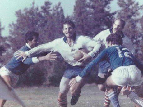 A group of men are playing rugby on a field.