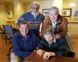 A group of men are posing for a picture while sitting around a table