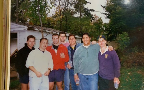 A group of people are posing for a picture in front of a house.