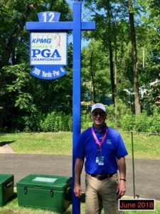 A man standing in front of a sign that says kpmg pga