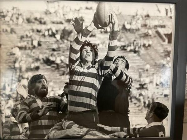 A group of men are playing rugby in a black and white photo.