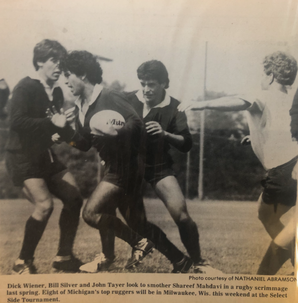 A black and white photo of men playing rugby