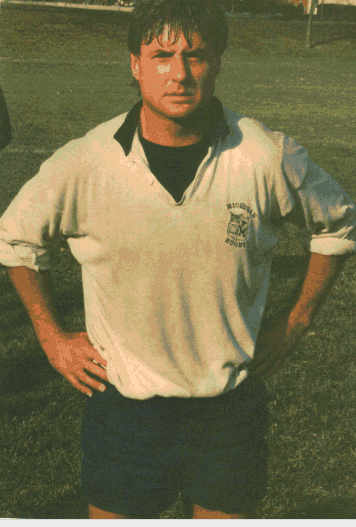 A man wearing a white shirt with the word rugby on it