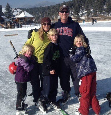 A man wearing a clemson sweatshirt poses with his family