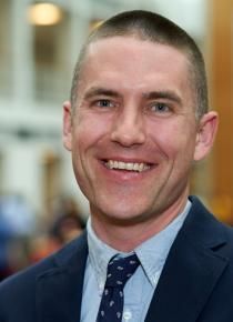 A man in a suit and tie is smiling for the camera.