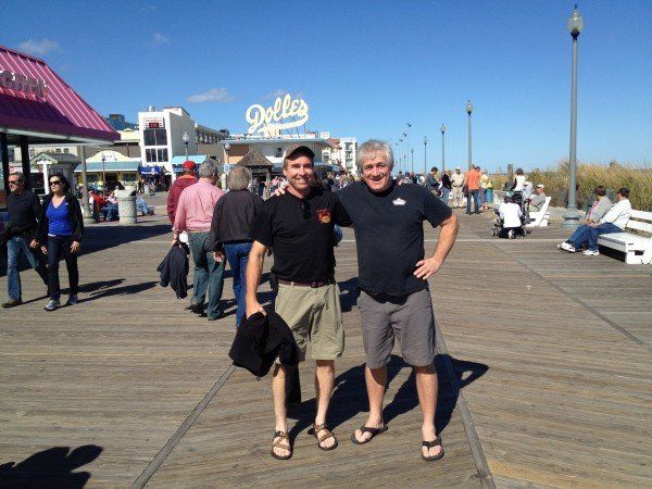 Two men standing on a boardwalk in front of a delta restaurant