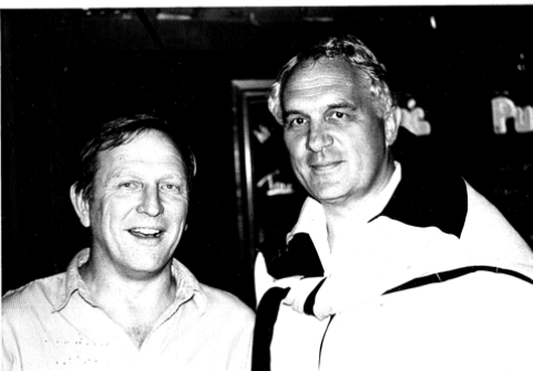 Two men are posing for a picture in a black and white photo