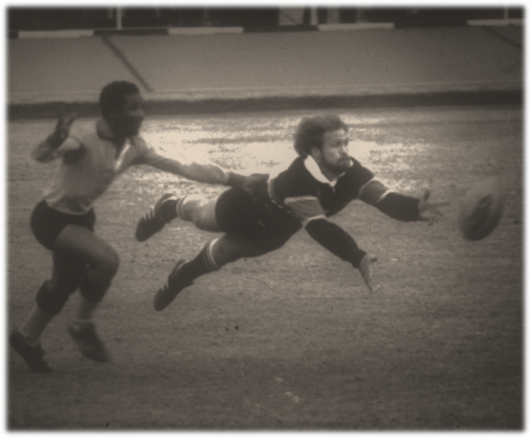 A black and white photo of two men playing rugby