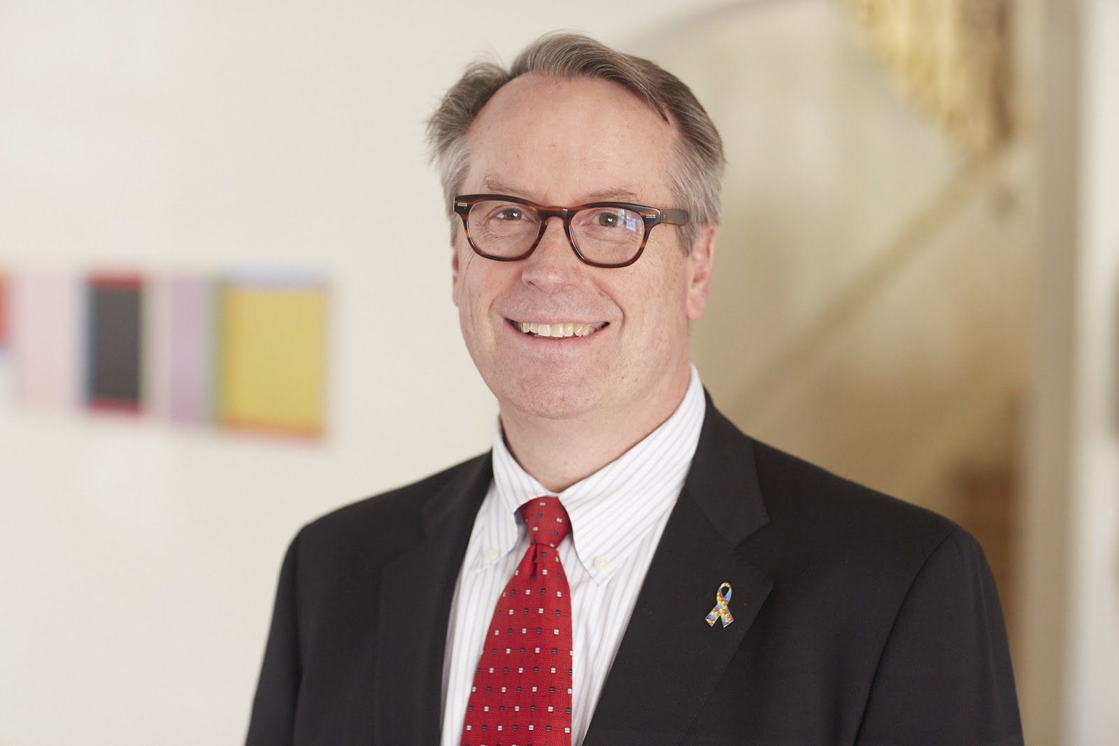 A man in a suit and tie is smiling for the camera.