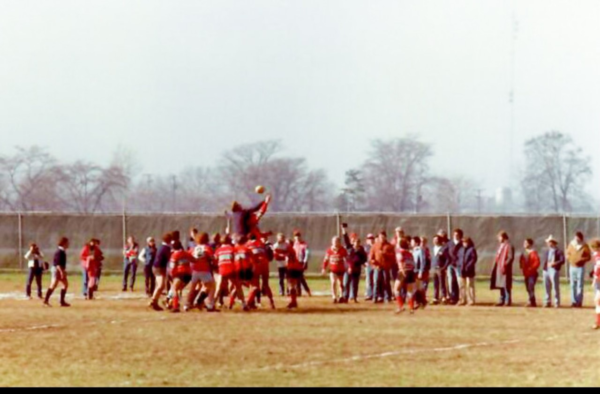 A group of people are playing a game of rugby on a field