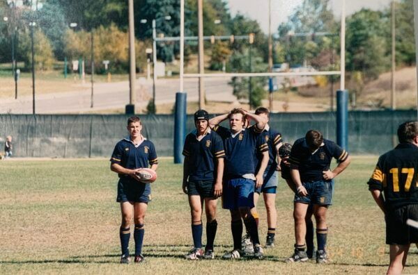 A group of men standing on a field with one wearing a number 17 jersey