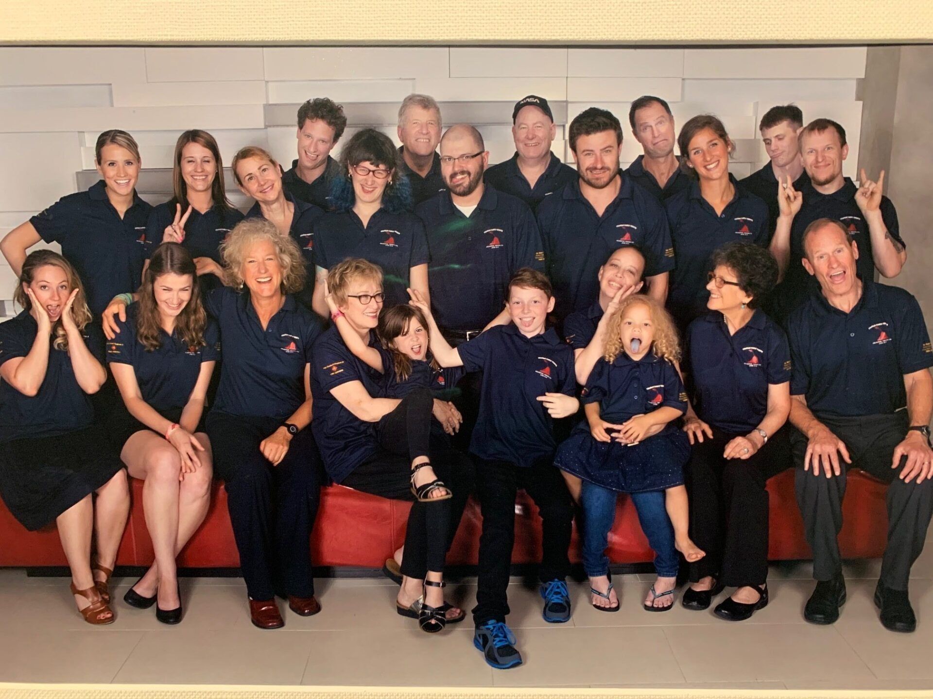 A large group of people in blue shirts are posing for a picture