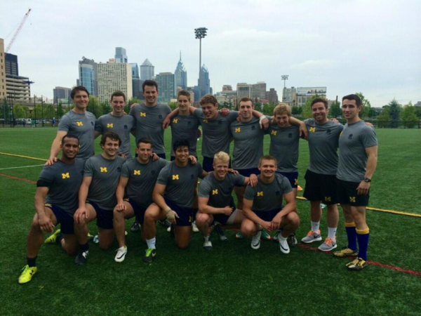 A group of men are posing for a picture on a field