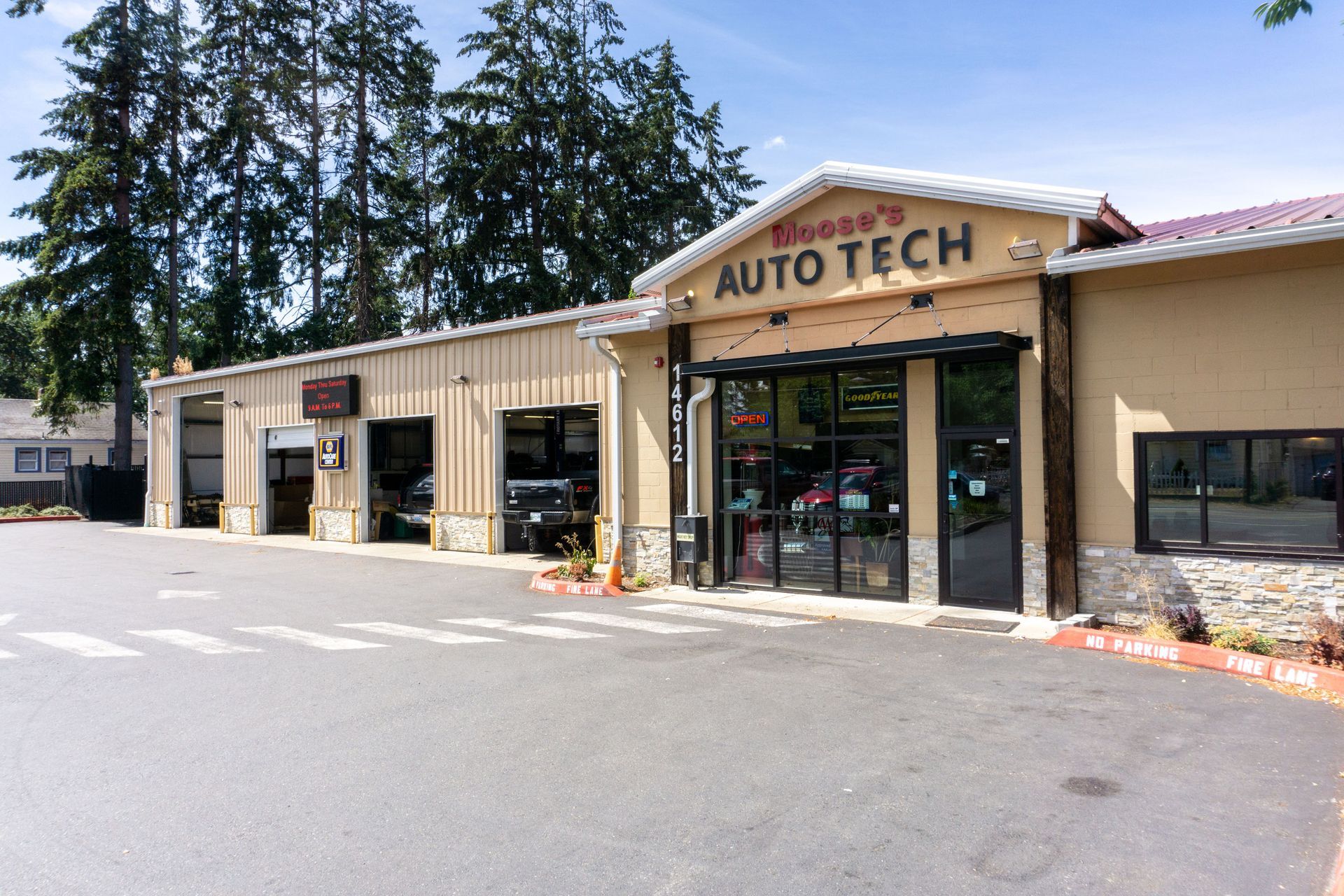 Exterior of Moose's Auto Tech; building with garage bays, black doors, and signage.
