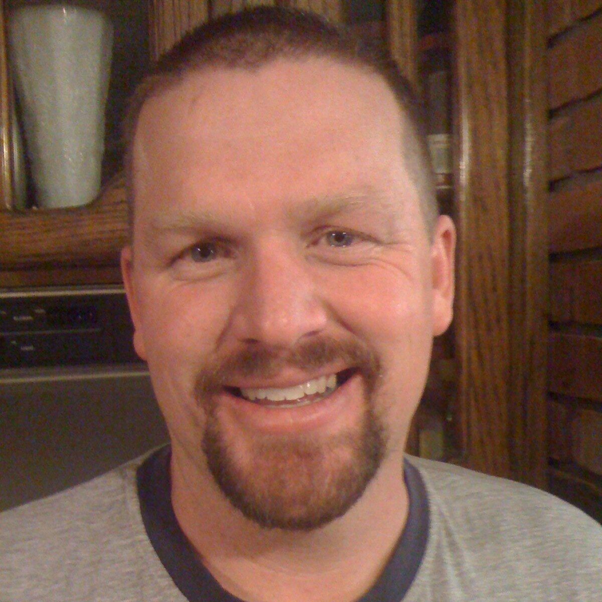 A man with a beard is smiling for the camera