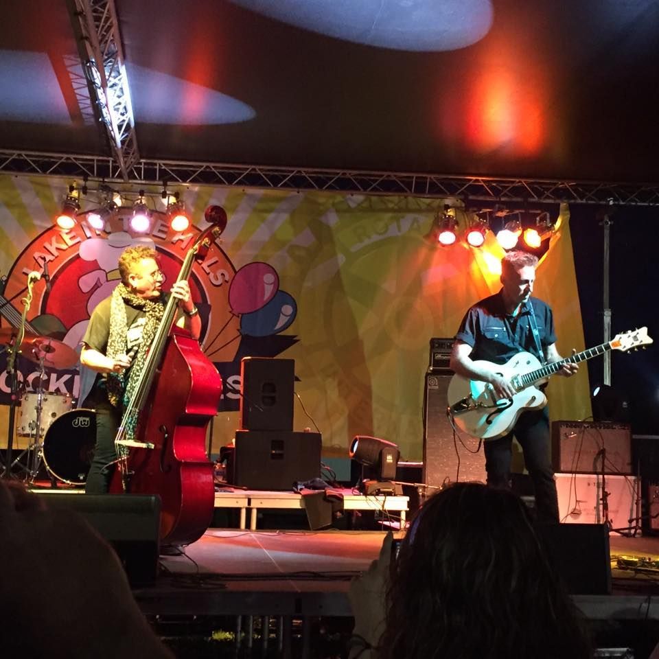 A man playing a double bass and a man playing a guitar on stage