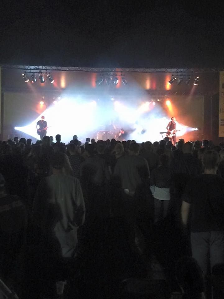 A crowd of people watching a band on stage