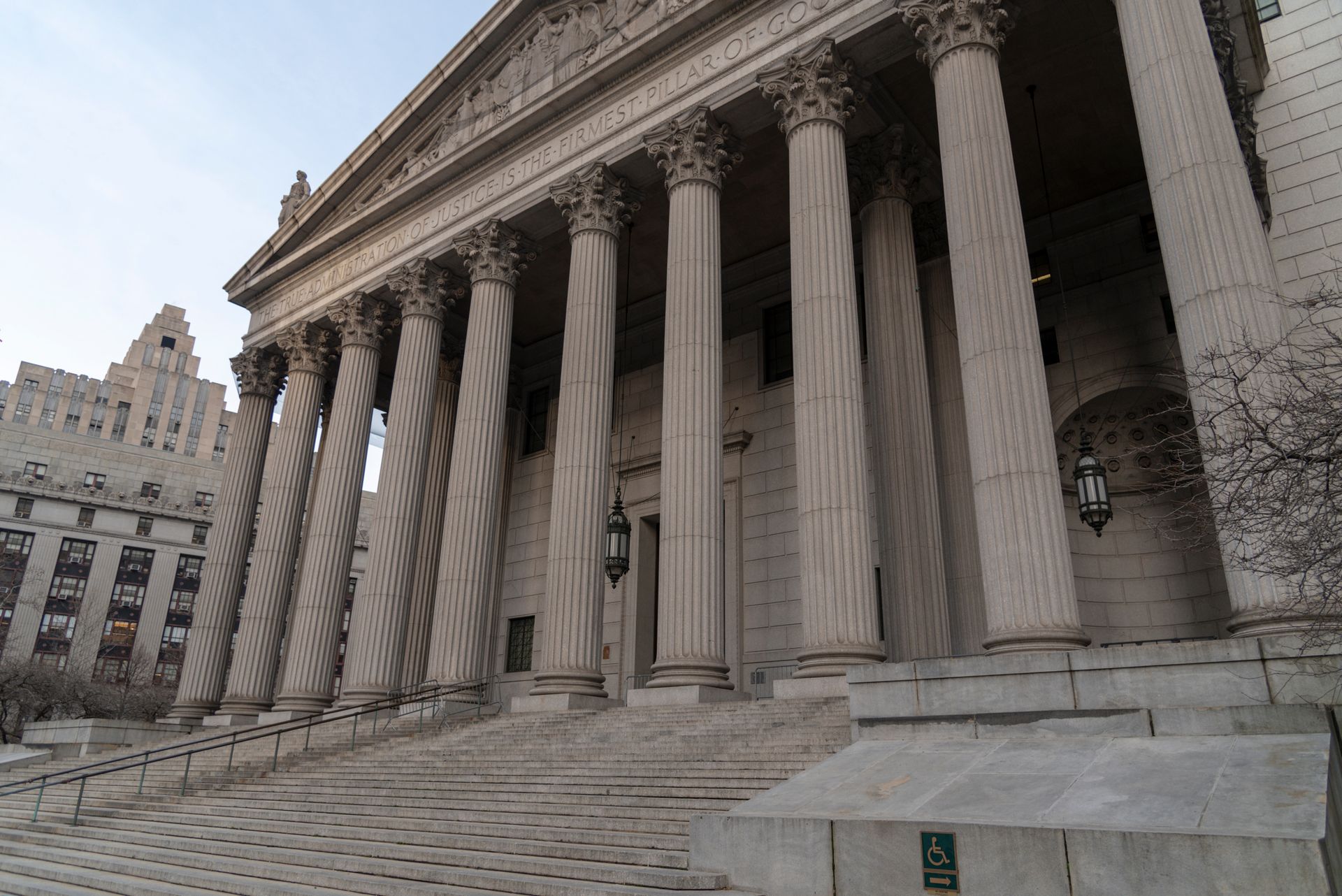 Grand neoclassical courthouse with tall stone columns and broad steps in a city setting