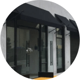 A store front with a black awning over the door.