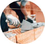 A man is laying bricks on a wall with a trowel.