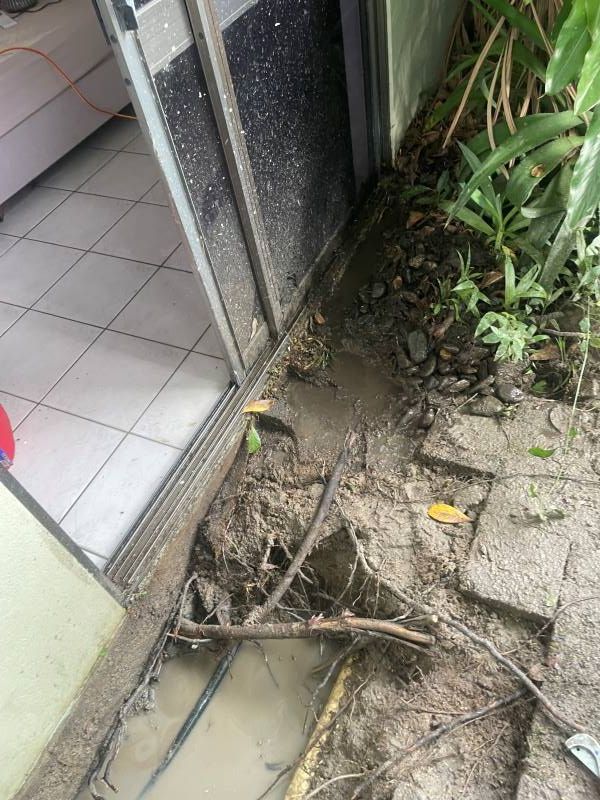 A Muddy Area Next to A Sliding Glass Door in A House — Smooth Flow Plumbing Cairns in Cairns City, QLD
