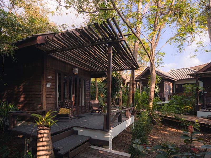 Cabanas de madeira com varandas cobertas em um ambiente verdejante e exuberante.
