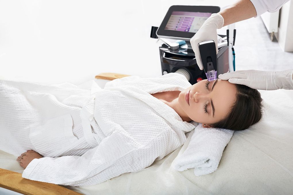 a woman is laying on a bed getting a facial treatment