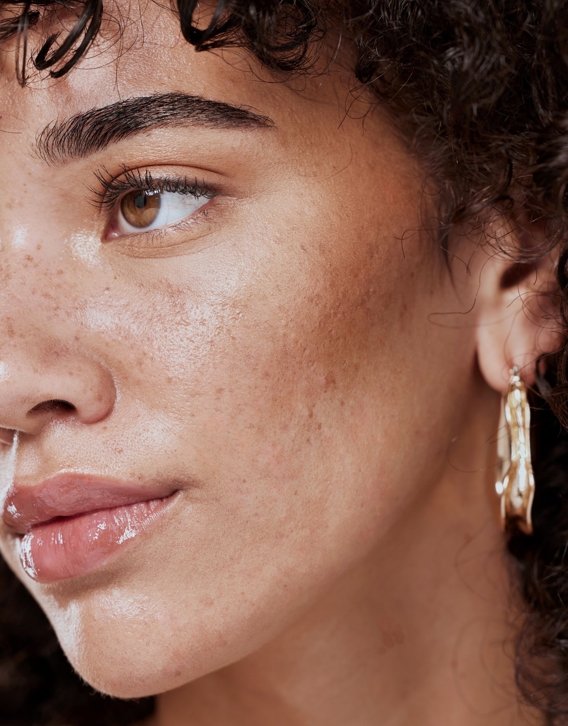 a close up of a woman 's face wearing hoop earrings