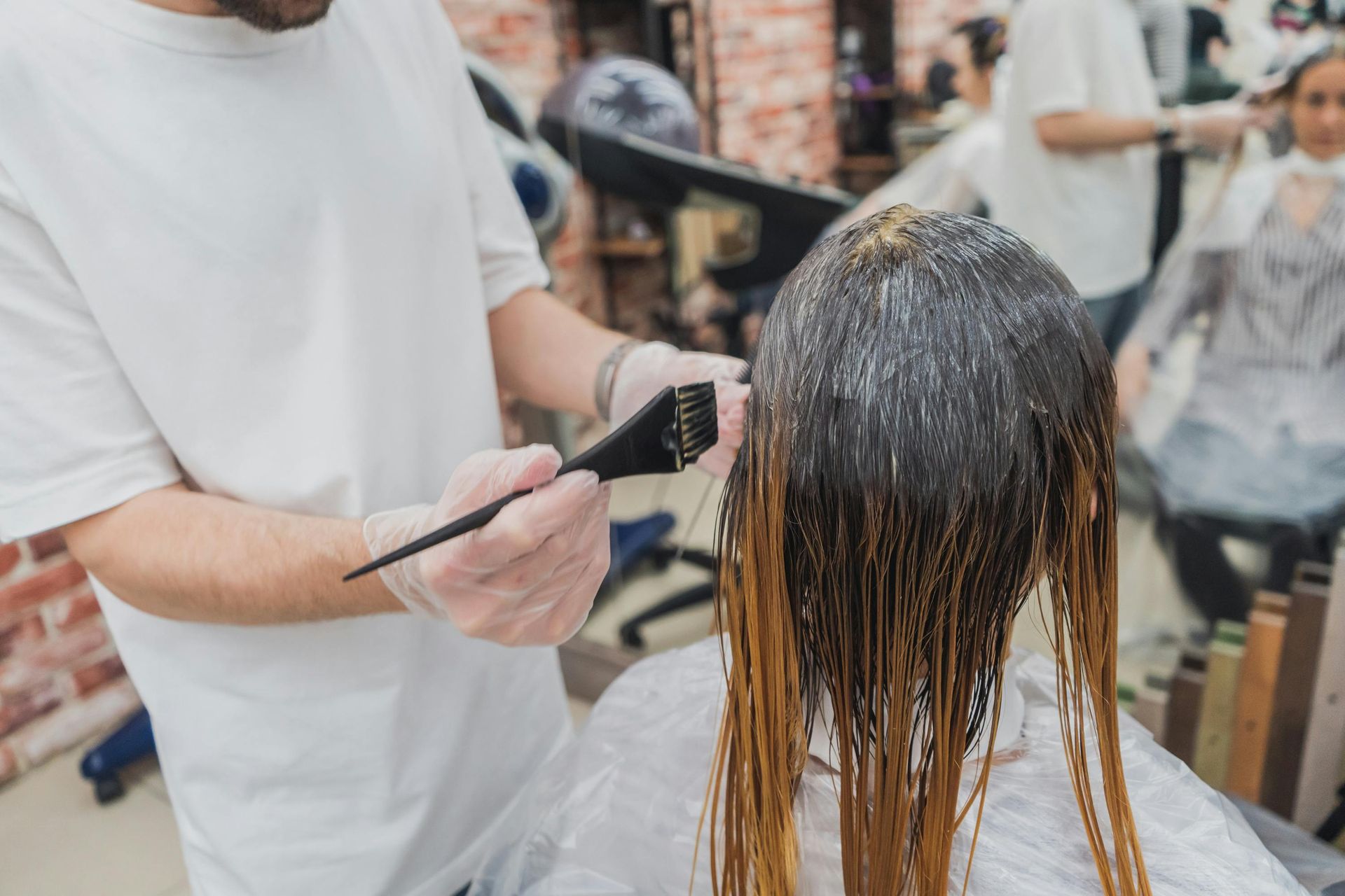 A woman is getting her hair dyed by a hairdresser in a salon.